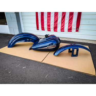 A set of dark blue motorcycle fenders and a fuel tank.